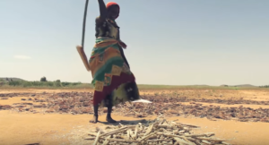 A lady smashing millet, a staple food of the Maramara people