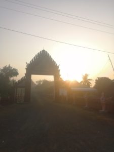 The sun setting between the arches of a temple