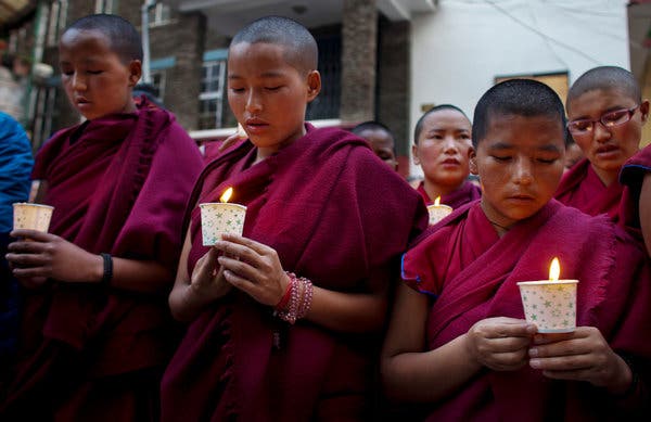 Monks lighting candles for the deceased.